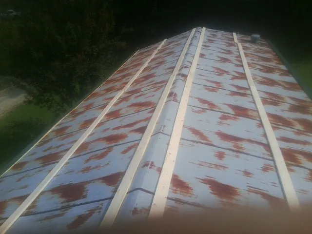 Rusted metal roof panels with new wood purlins before replacement — Storm Damage Roof Repair in Delanson by Roofing Brothers