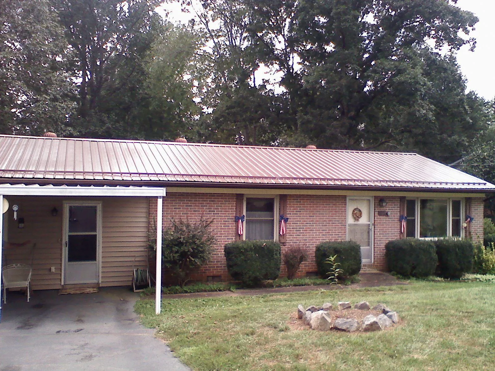 Bronze metal roof and carport on a brick ranch home — Roof Repair work by our crew in Delanson